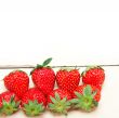fresh organic strawberry over white wood