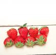 fresh organic strawberry over white wood