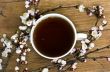 tea with apricot flowers and branches on table, top view