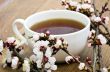 tea with apricot flowers and branches on table, top view