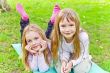 Two girls sitting on grass