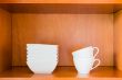 Organized minimalistic kitchen cabinet with white porcelain bowl