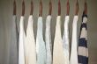 A row of warm and soft sweaters for women on wooden hangers in a